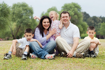 Fototapeta premium Portrait of happy family of five on the green land