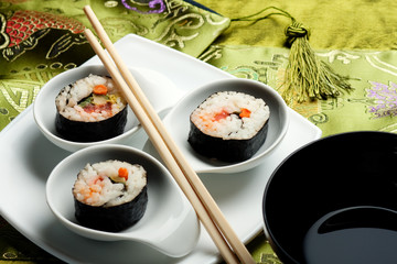 Sushi rolls on japanese silk  with soy