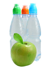 Apple in front of bottles of water isolated on white