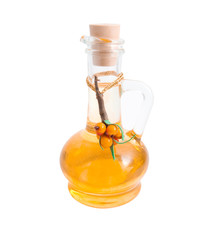 Jug with vegetable oil and sea-buckthorn berries branch