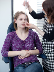 optometry concept - pretty young woman having her eyes examined