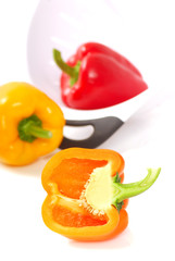 Orange, yellow and red bell peppers with a strainer