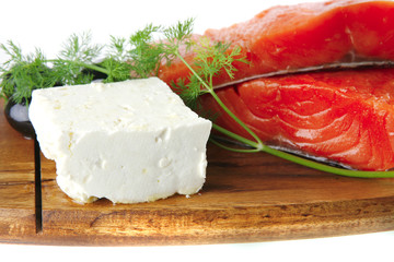 pink smoked salmon on wooden plate with white cheese