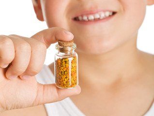 Little boy holding small bottle of pollen - closeup