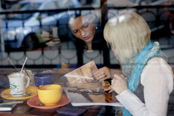 Girls in cafe. The photo through glass