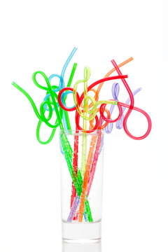 Colorful straws in glass isolated on a white background