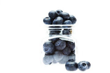 blueberries in a glass bottle isolated on white