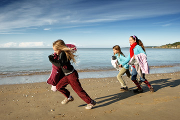 Trois enfants font la course sur la plage