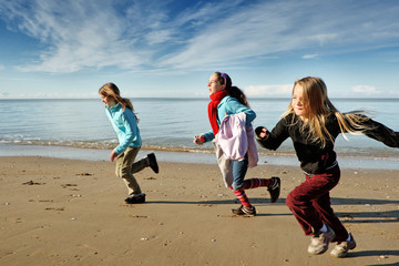 Trois enfants font la course sur la plage