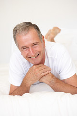 Senior Man Relaxing On Bed