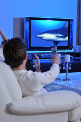 Two boys on couch watching sea documentary on TV