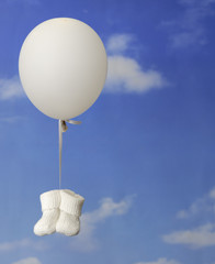 concept de naissance: chaussons de bébé pendu a un ballong