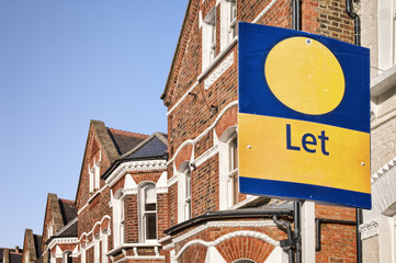 A typical red-brick townhouse with " Let" sign , London.