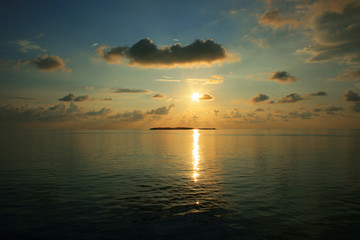 Naklejka na ściany i meble Sonnenuntergang über einer Insel