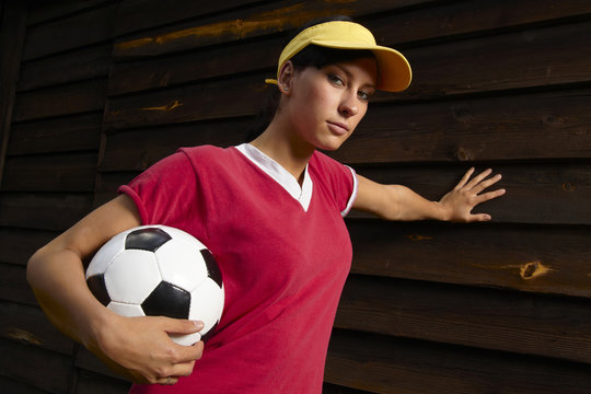 junge dunkelhaarige Frau posiert mit Fussball