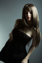 The young beautiful girl in black dress with developing hair