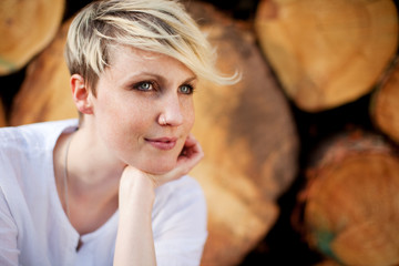 blonde frau mit baumstämmen