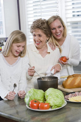 Three generation family in kitchen cooking lunch