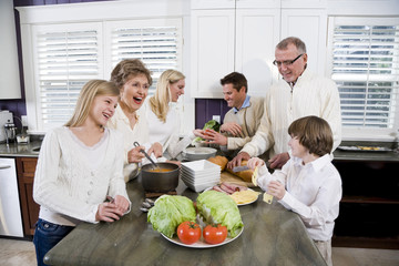 Three generation family in kitchen cooking lunch