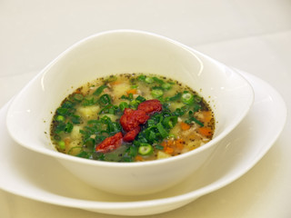 potato soup with sausage slices on a stylish white bowl