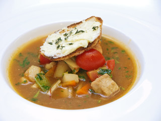 vegetable and meat soup served with crusty bread and butter