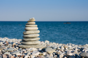 Fototapeta na wymiar White pebbles stacked on sea shore