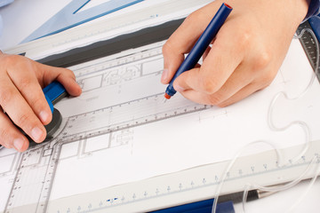 Architect working on architectural plans in the office