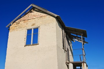 Fototapeta na wymiar abandoned concrete house on a blue sky background