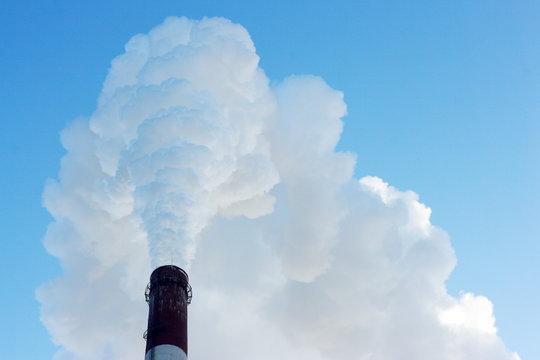 Smoking stack of thermal power station against a blue sky