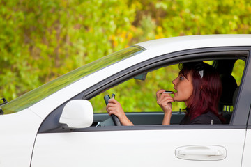 Woman in a car doing makeup.