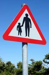 British pedestrians in road sign and blue sky.