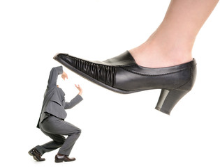 Businessman is kicking by a big foot of a woman