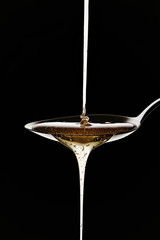 Colher e mel sobre fundo preto © Rogério Andrade