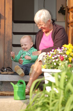 Grandmother with grandchild sitting on a stair_outdoor