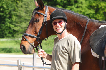Mann mit Pferd fertig zum Ausritt