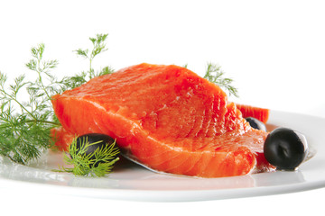 fresh smoked salmon on white plate with olives