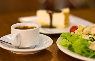 Cup of espresso with cake and salad