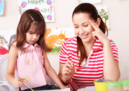 Child playing with teacher in preschool.