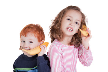 Two happy kids talking on banana phones