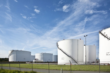 white tanks in tank farm with blue sky