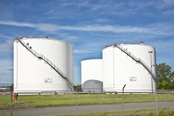 white tanks in tank farm with blue sky
