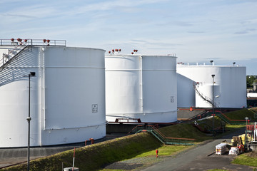 white tanks in tank farm with blue sky