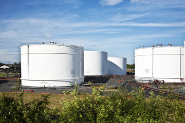 white tanks in tank farm with blue sky