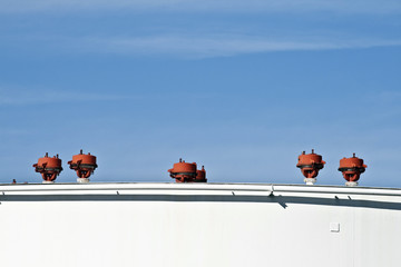 white tanks in tank farm with blue sky