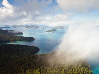 Aerial view of the Whitsunday Islands through misty clouds