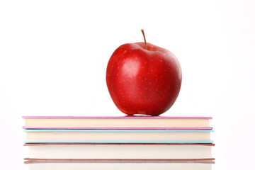 red apple on a book isolated on white