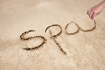 spa handwritten in sand on a beach