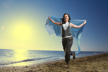 Joyful woman running at sea shore