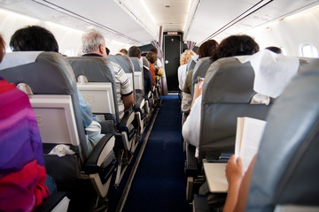 Plane passengers inside airplane interior - obrazy, fototapety, plakaty