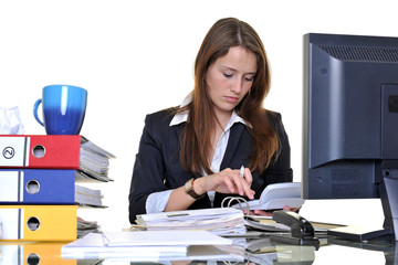 Junge Frau arbeitet im Büro zwischen Akten und PC
